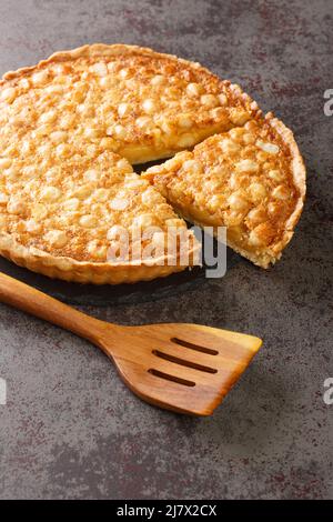 Tart with macadamia nuts and custard close-up on a slate board on the table. vertical Stock Photo