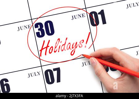 30th day of June. Hand drawing a red circle and writing the text Holidays on the calendar date 30 June. Important date. Summer month, day of the year Stock Photo