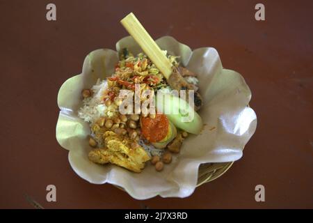Balinese nasi campur (mixed rice) at a restaurant in Denpasar, Bali, Indonesia. Stock Photo