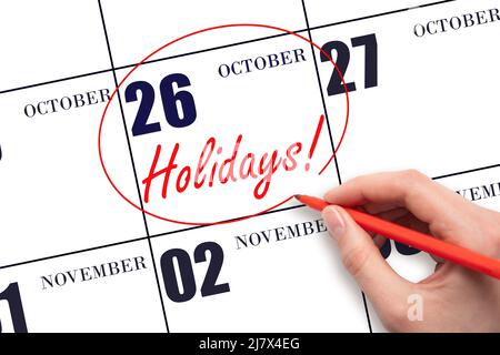 26th day of October. Hand drawing a red circle and writing the text Holidays on the calendar date 26 October. Important date. Autumn month, day of the Stock Photo