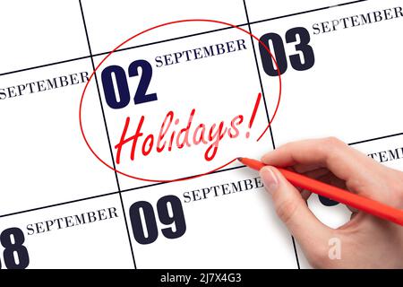 2nd day of September. Hand drawing a red circle and writing the text Holidays on the calendar date 2 September . Important date. Autumn month, day of Stock Photo