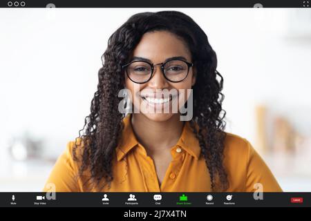 Smiling black woman wearing eyeglasses having video chat Stock Photo