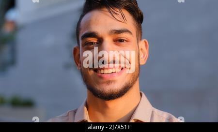 Moving camera hispanic business man happy arabian bearded guy satisfied cheerful carefree model smiling toothy looking at camera with friendly Stock Photo