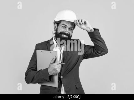 Architect in hardhat holding blueprints and greeting by touching helmet, welcome on board Stock Photo