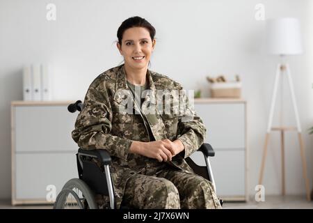 Rehabilitation Programs For Veterans. Portrait Of Happy Military Woman Sitting In Wheelchair Stock Photo