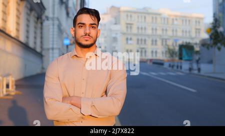 Man portrait hispanic arabic indian business man guy boss leader manager in formal clothes pensive thinking dreaming standing in city on street on Stock Photo