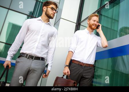 Two successful business men walking outdoors. Business, friendship, communication concept Stock Photo