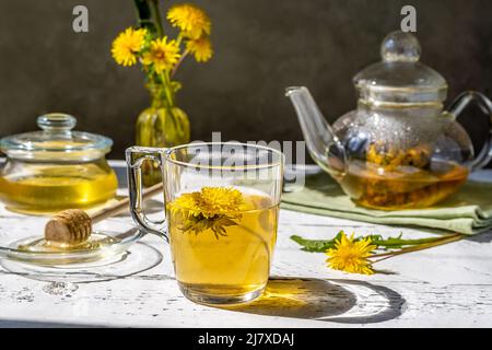 Dandelion honey and tea on the white wooden table with tea pot, dandelion flowers, mix for tea Stock Photo
