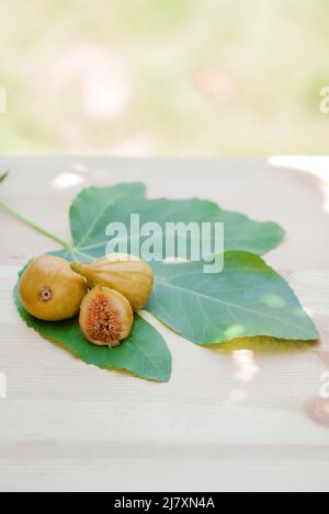 Ripe sweet figs. Healthy mediterranean fig fruit figs on rustic background with green leaf Stock Photo