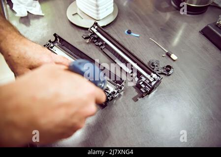 hands repairing laser toner cartridge, screw removal Stock Photo