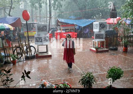 Dhaka, Bangladesh - May 11, 2022: People walk through the park during rainy day at Dhaka in Bangladesh. Stock Photo