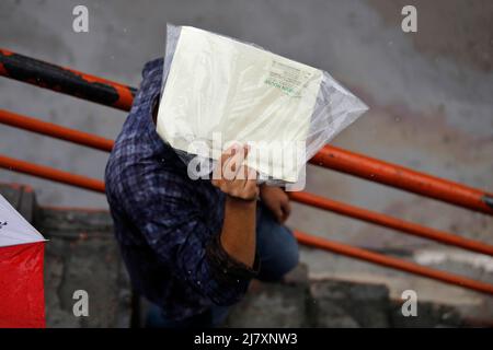 Dhaka, Bangladesh - May 11, 2022: People walk through the park during rainy day at Dhaka in Bangladesh. Stock Photo