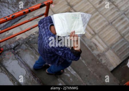 Dhaka, Bangladesh - May 11, 2022: People walk through the park during rainy day at Dhaka in Bangladesh. Stock Photo