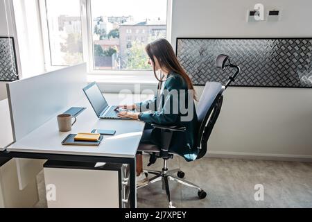 Young female programmer web developer working on computer software in modern office. Web Designer Woman working at her desk in open plan office Stock Photo