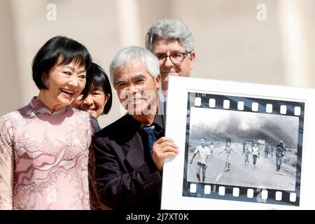 Vatican City, Vatican City. 11th May, 2022. Vietnamese-American photographer Nick Ut (R), flanked by Phan Thị Kim Phuc, known as the 'Napalm Girl', shows his Vietnam war iconic photo as they wait to meet Pope Francis at the end of his weekly general audience in St. Peter's Square at the Vatican City, Vatican, 11 May, 2022. Credit: Riccardo De Luca - Update Images/Alamy Live News Stock Photo