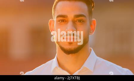 Portrait outdoors arabic hispanic spaniard business man boss leader guy businessman wears white shirt standing outside looking at camera posing at Stock Photo