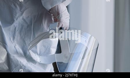 Unrecognizable doctor medical worker nurse practitioner scientist stands in clinic laboratory hospital at window wears white uniform and latex gloves Stock Photo