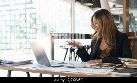 Asian business woman talking to colleague team about plan in video conference. Group of multiethnic business people using computer for online meeting