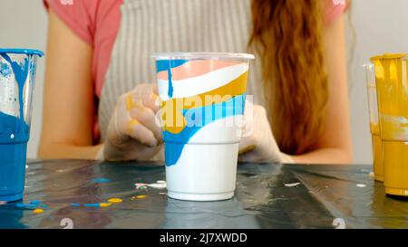 Fluid art technique. Female artist works on abstract fluid art painting. Stock Photo