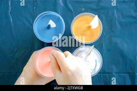 Fluid art technique. Artist works on abstract fluid art painting. Stock Photo