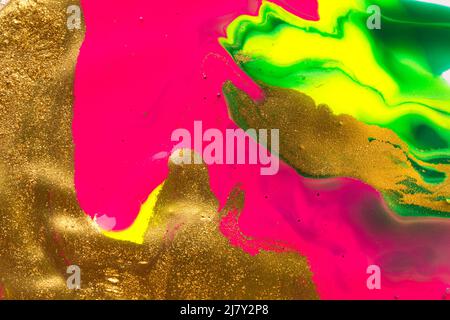 Gold foil abstract background with fluorescent pink parts. Stock Photo