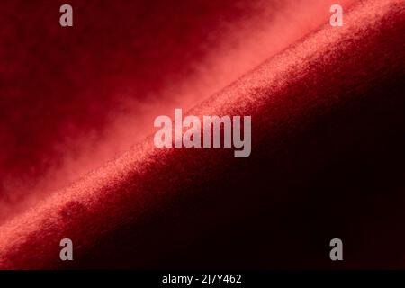 Soft velour red wrinkled fabric macro photo, fabrics on the example of upholstered furniture Stock Photo