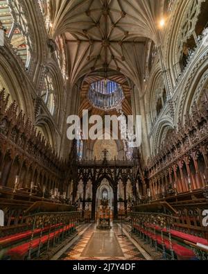 The choir stalls, carved wooden rood screen, Octagon Tower and Lantern of Ely Cathedral Stock Photo