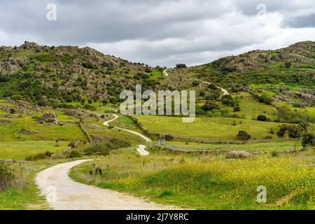 Dirt road that winds through the mountain on a cloudy day, Guadarrama Madrid. Stock Photo