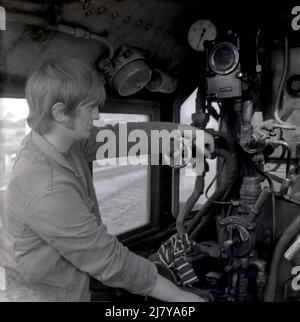 1969, historical, inside the cab, a train driver or operator at the controls of a steam-powered locomotive, England, UK. Stock Photo