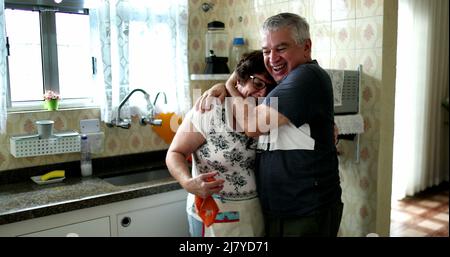 Husband celebrating success with wife. Older married couple hugging and kissing Stock Photo