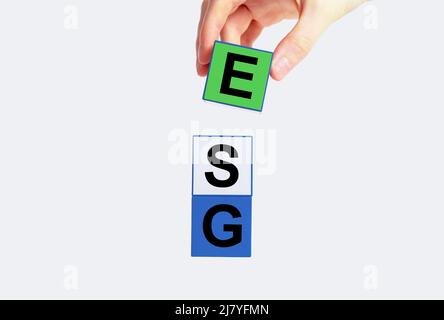 Environmental, social and governance criteria concept. ESG letters at cubes put by woman hand. Standards for company sustainability evaluation. Factors for investing. High quality photo Stock Photo