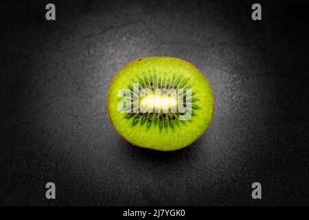 Sliced half kiwi isolated with dark background Stock Photo