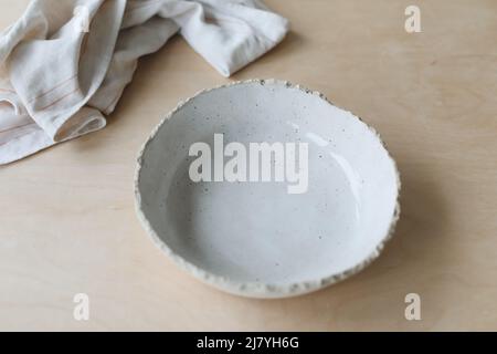 Ceramic bowl on a wooden table top view. Handmade ceramic tableware and pottery Stock Photo
