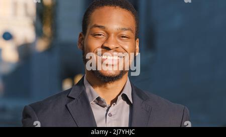 Young mixed race male office worker professional intern with happy face posing alone outdoor close up portrait. Happy African American businessman Stock Photo
