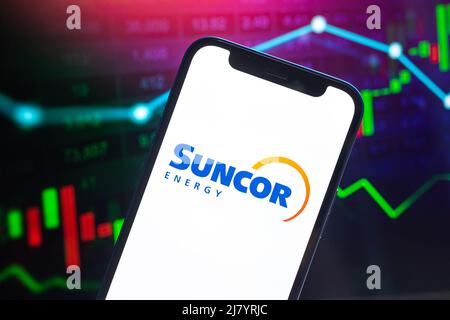 Poltava, Ukraine - May 11, 2022: Suncor logo company, gas and oil prices, energy industry. Petroleum stock market graphs, global financial background. Stock Photo