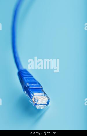 Blue UTP Internet Cable - Isolated on a blue background Ethernet Cord Stock Photo