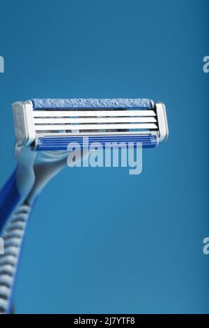 Blades of a new shaving machine on a blue background close-up free space Stock Photo