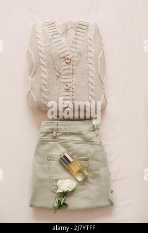 Stylish female accessories, clothes and perfume bottle on beige ...