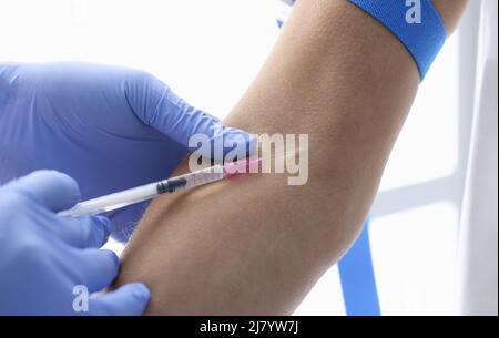 Nurse injects medication in womans vein with needle, blood test in hospital Stock Photo