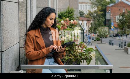 Serious focused busy pensive business woman with digital tablet girl with modern wireless gadget device chat browsing network distant works checking Stock Photo