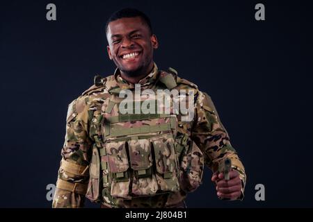 american man in camouflage suit aiming with a pistol Stock Photo