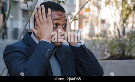 Pensive upset nervous black millennial student considering choice makes difficult decision outdoors, african american young adult businessman Stock Photo