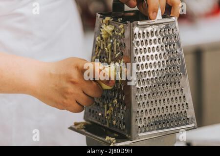 Cook's hand grating apples for apple pie Stock Photo