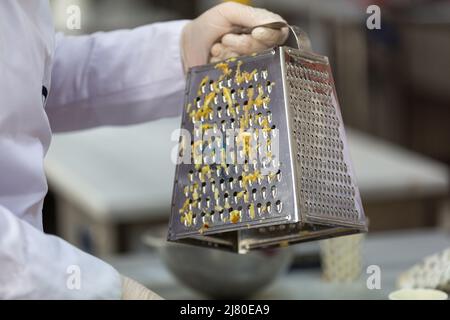 Cook's hand grating apples for apple pie Stock Photo