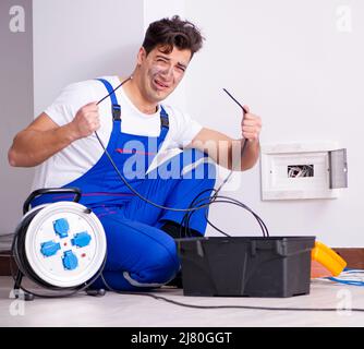 The funny man doing electrical repairs at home Stock Photo