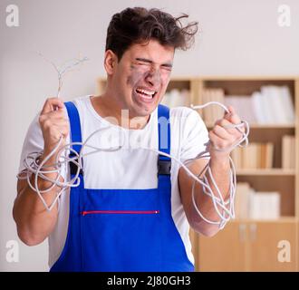The funny man doing electrical repairs at home Stock Photo