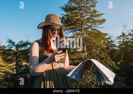 woman looking up the location of the hotel on her mobile phone when arriving at her travel destination. trip and leisure Stock Photo