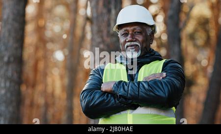 Mature african american confident male businessman standing outdoors professional forestry engineer foreman worker forester in uniform in protective Stock Photo