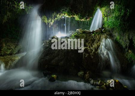 A small series of waterfalls plummets through the rocks in the S Stock Photo