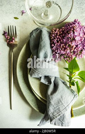 Overhead view of a spring place setting with lilac flowers Stock Photo